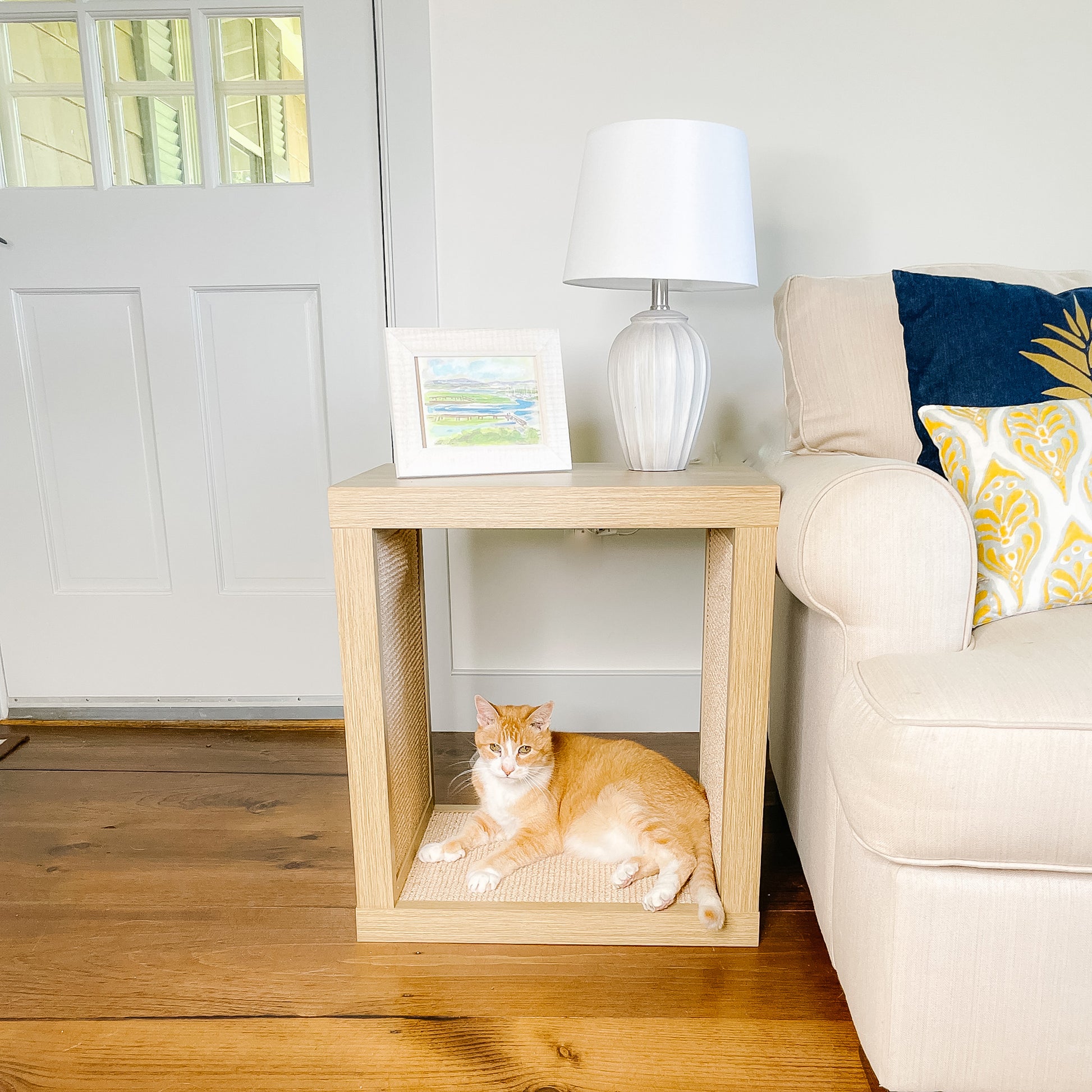 cat lying on wood cat scratcher end table next to couch