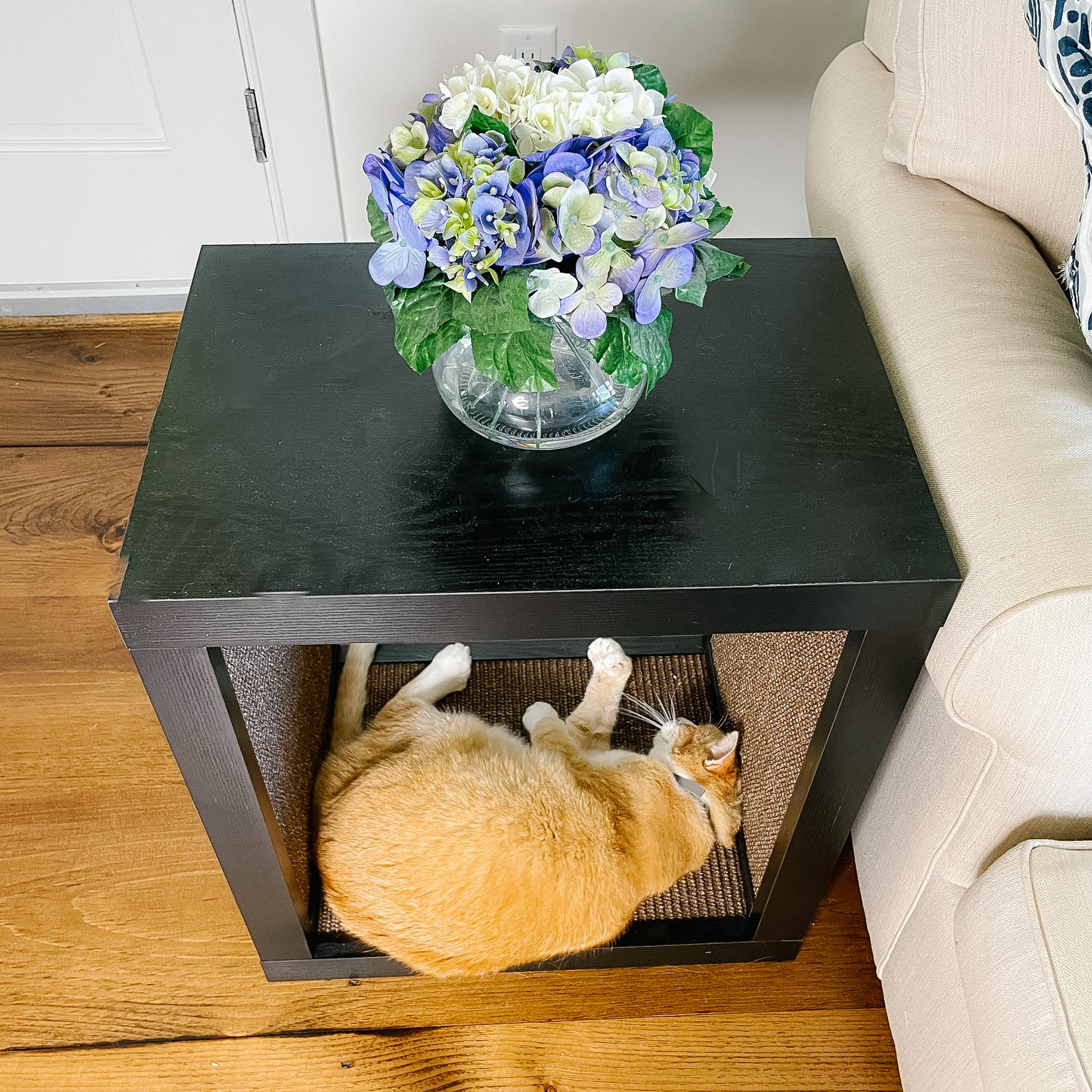 cat lying on wood cat scratcher end table and couch